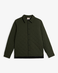 A front view of The Quilted Overshirt in Khaki, laid flat on a white background. The image highlights the signature wave quilting, the black button closure, and the c'est normal label at the inside of the neck.