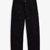 A front view of The Carpenter Pant in black, laid flat on a white background. The image highlights the double-knee panels, copper-toned rivets, slash pockets, and the embroidered c'est normal logo on the side seam.
