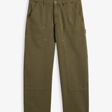A front view of The Carpenter Pant in olive green, laid flat on a white background. The image highlights the front slash pockets, reinforced knee panels with rivets, and the embroidered c'est normal logo.