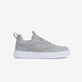 A side view of The Dynamic Waterproof Sneaker 2.0 Low in grey, placed on a white background. The image highlights the sleek waterproof upper, lace-up design, and the thick white EVA rubber grid sole.