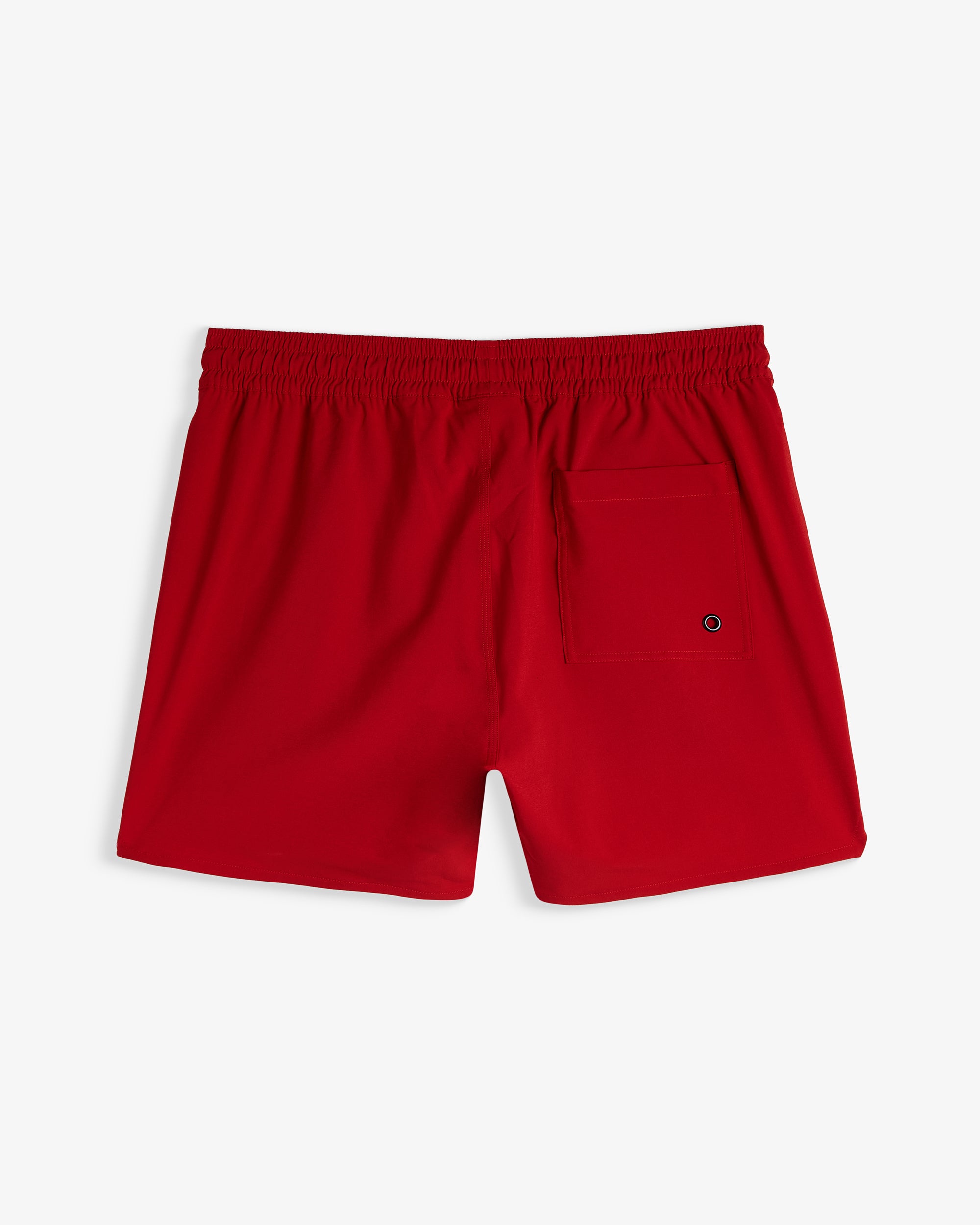A back view of The Shorts in red, laid flat on a white background. The image highlights the elastic waistband and the back pocket with an eyelet.
