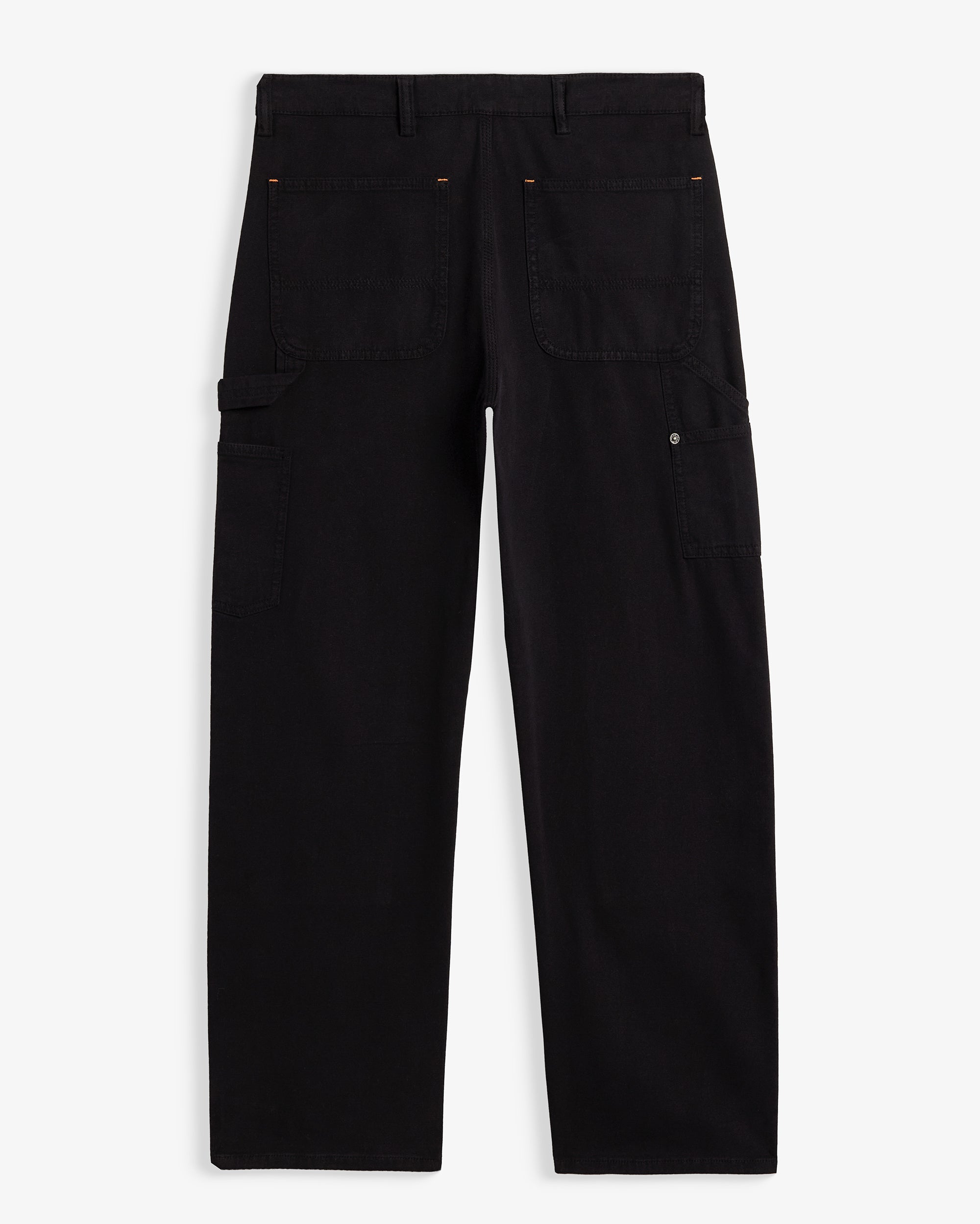 A back view of The Carpenter Pant in black, laid flat on a white background. The image highlights the two back pockets, a hammer loop, side leg pockets, and a c'est normal logo patch on the back right pocket.