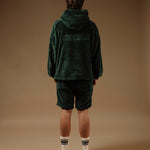 The Oversized Teddy Hoodie in pine — back view showing the embossed C'est normal logo