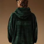 The Oversized Teddy Hoodie in pine — back view with the embossed C'est normal logo