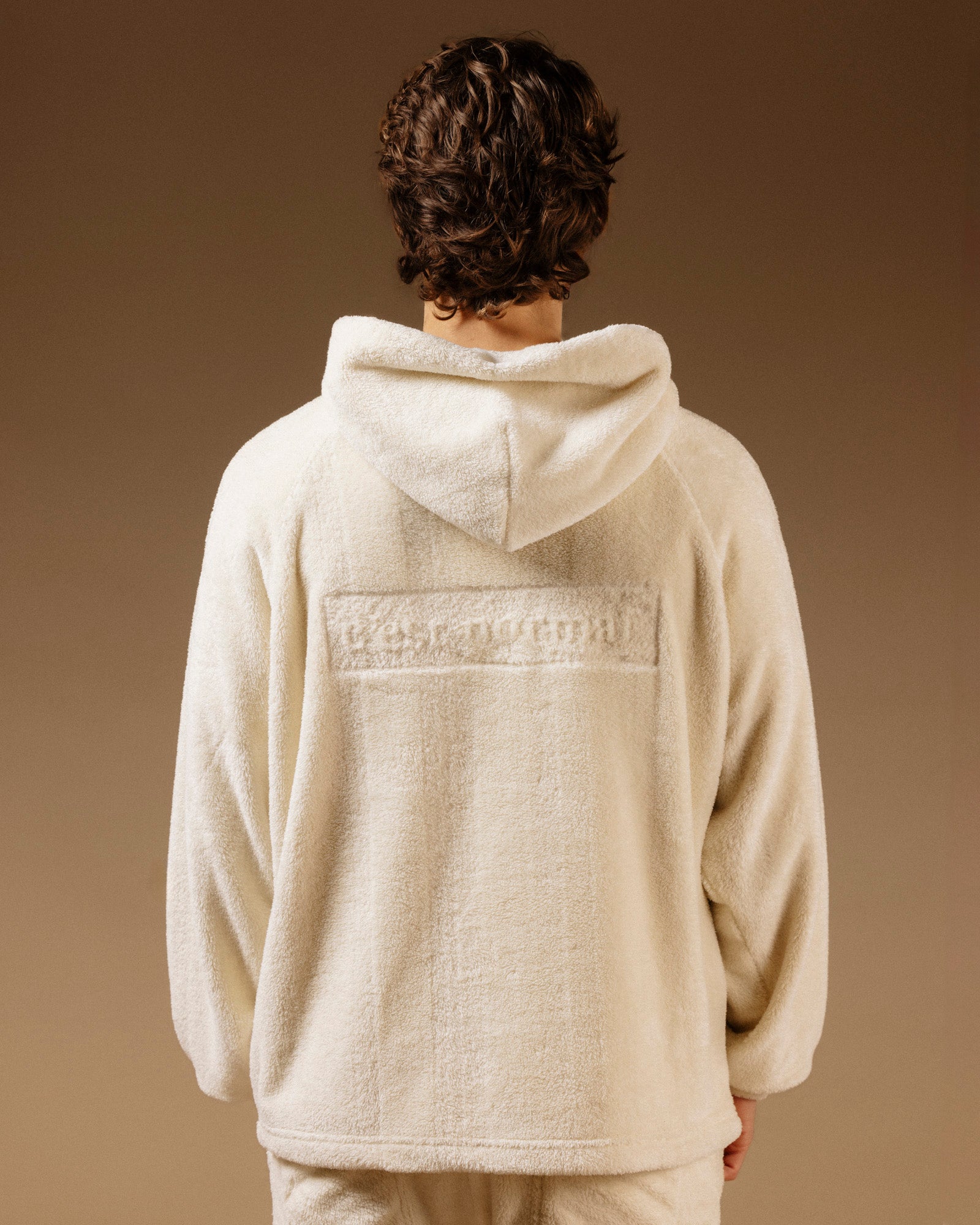 The Oversized Teddy Hoodie in cream — back view showing the embossed C'est normal logo