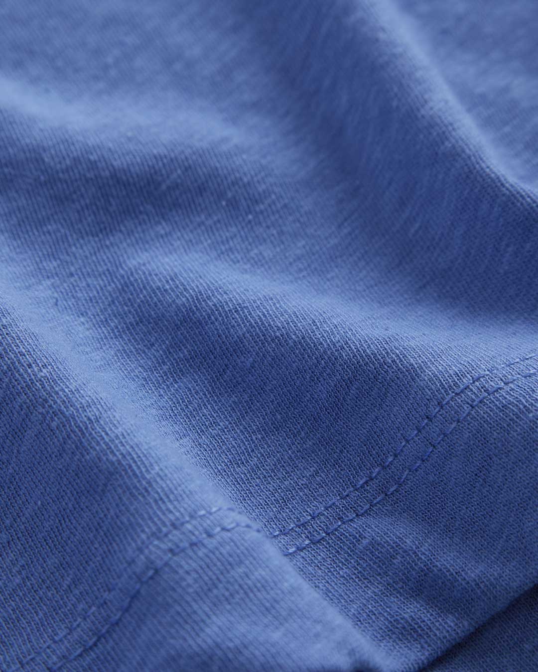 Le Linen T-Shirt in azure — close-up of the textured fabric and hem stitching