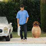 Le Linen T-Shirt in azure — worn by a pool next to a vintage white car