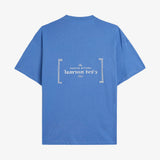Le Linen T-Shirt in azure — back view showing the white C'est normal French Riviera Club logo