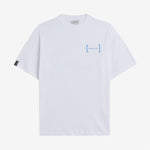 Le Linen T-Shirt in white — oversized fit with a blue chest logo and black cuff tag