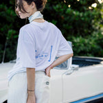 Le Linen T-Shirt in white — back view with the French Riviera print next to a vintage car