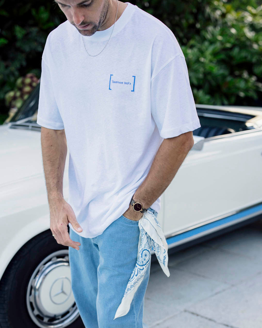 Le Linen T-Shirt in white — worn with blue jeans next to a white vintage car