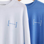 Le Linen T-Shirt in white — hanging next to a blue version with the C'est normal logo