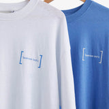 Le Linen T-Shirt in white — hanging next to a blue version with the C'est normal logo