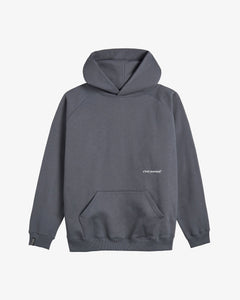 A front view of The Kangaroo Hoodie in carbon grey, laid flat on a white background. The image highlights the front kangaroo pocket, the hood without drawstrings, and the small white c'est normal logo below the chest.