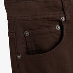 A close-up shot of the front and coin pockets on The 5 Pocket Pants in brown. The image highlights the branded rivets featuring the c'est normal logo and a touch of orange accent stitching.