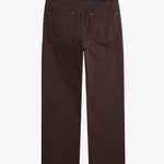 A back view of The 5 Pocket Pants in brown, laid flat on a white background. The image highlights the two back pockets, belt loops, orange accent stitching, and the black rubber patch with the white c'est normal logo.