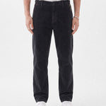 The Daily Cord Chino in anthracite grey — front model view wearing white sneakers