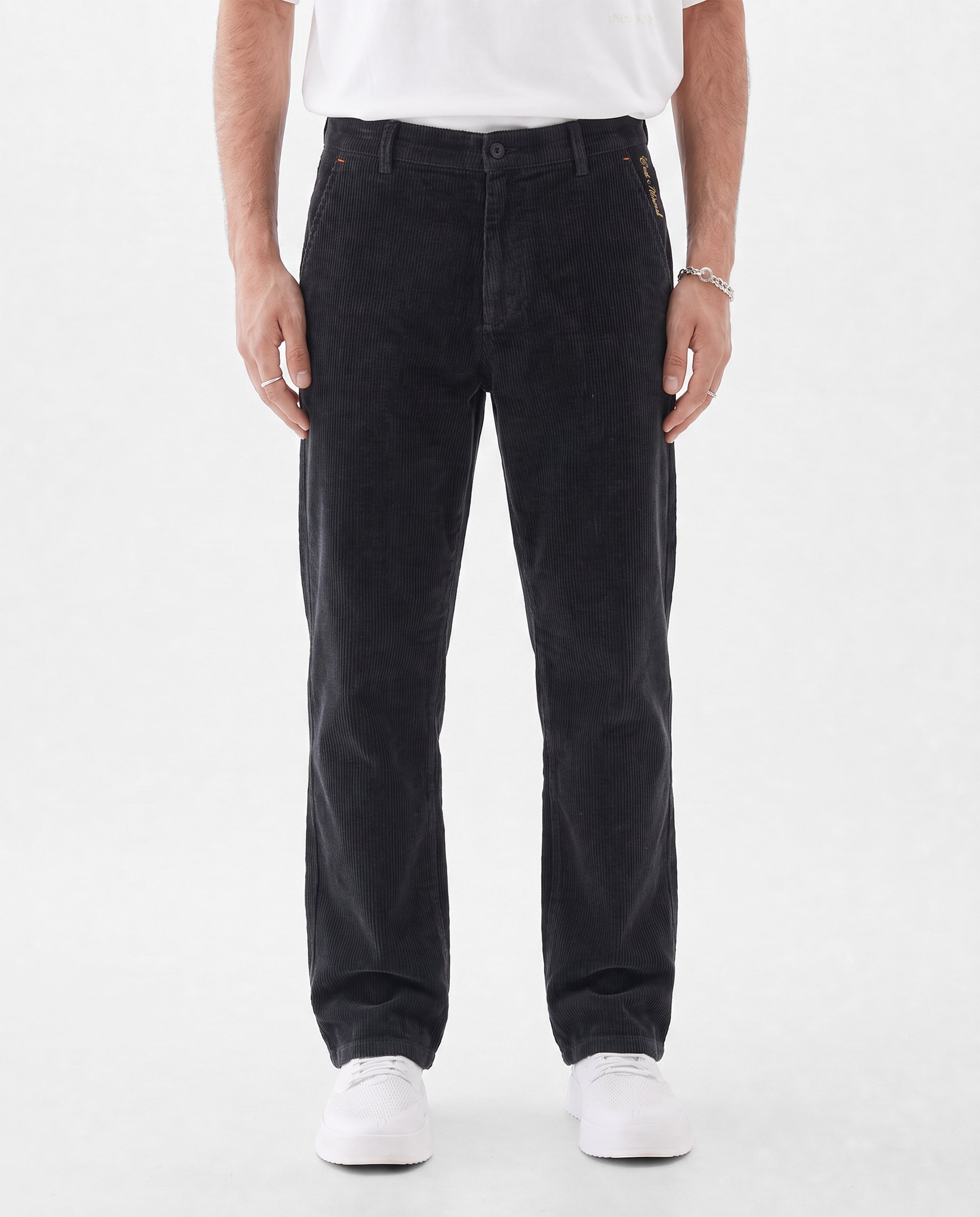 The Daily Cord Chino in anthracite grey — front model view wearing white sneakers