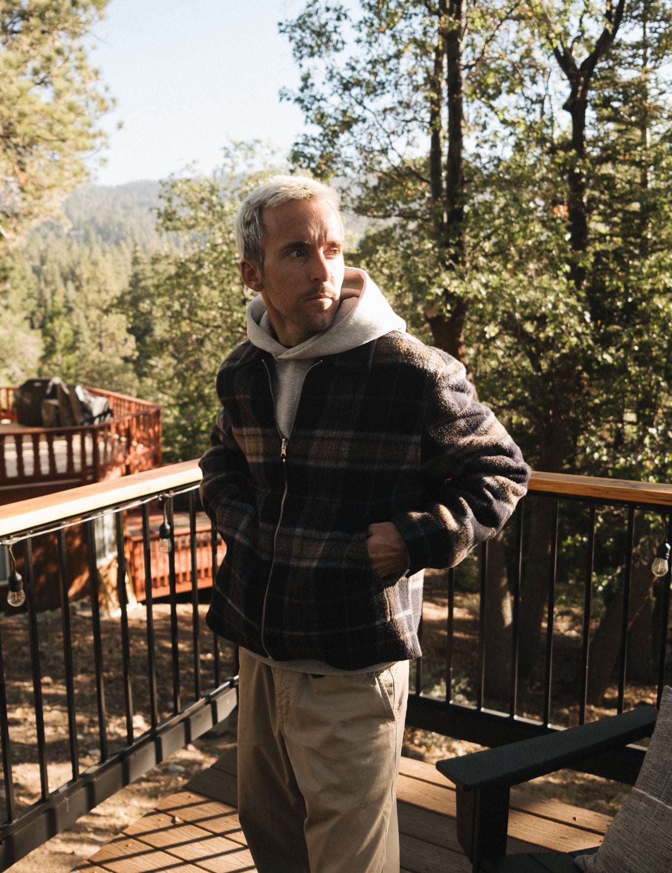 The Reversible Wool Jacket in plaid — worn outdoors with a hoodie