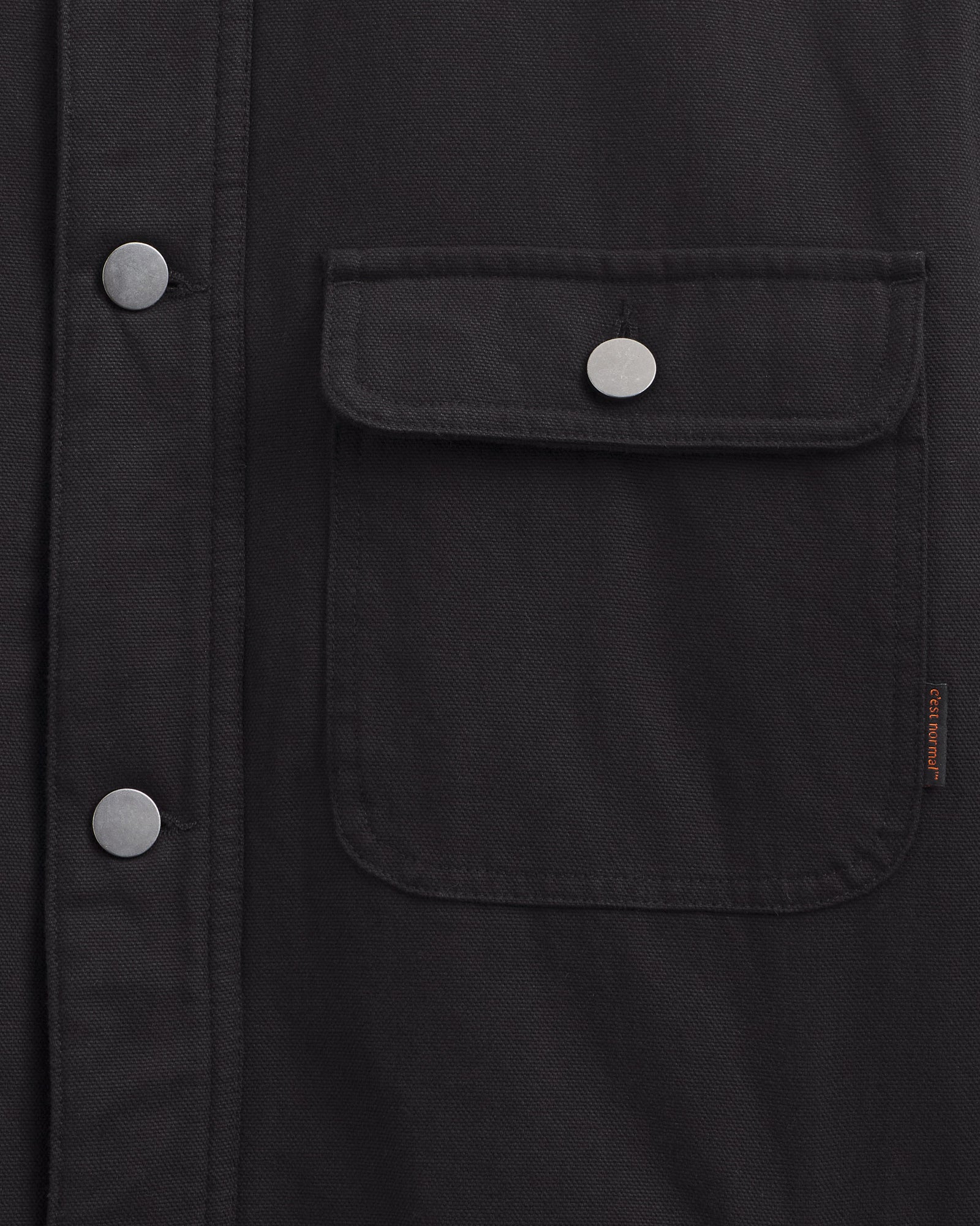 Denver Canvas Jacket in black — close-up of the chest pocket and metal buttons