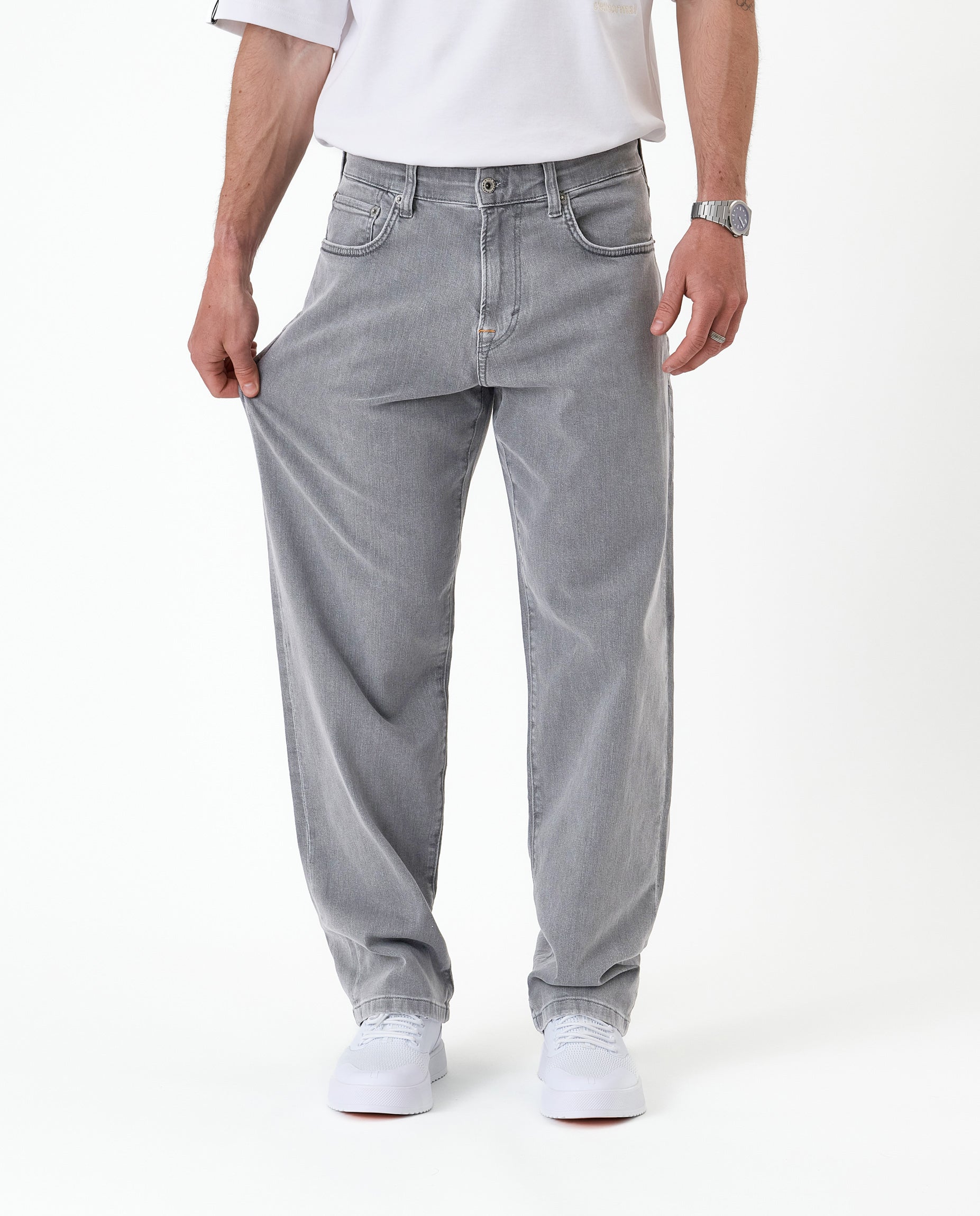 The Jeans Relaxed Straight Fit in light grey — demonstrating fabric stretch
