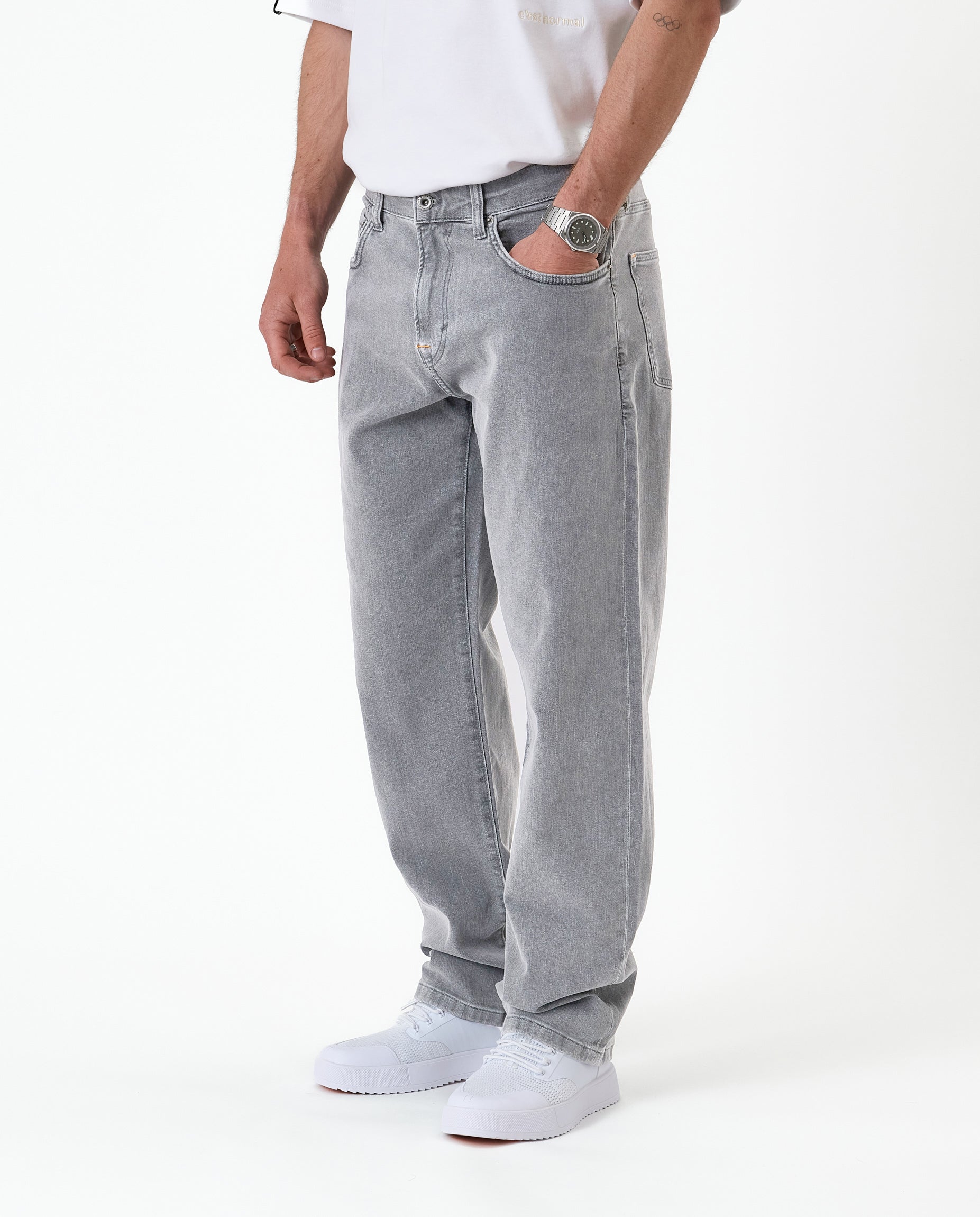 The Jeans Relaxed Straight Fit in light grey — worn with white sneakers