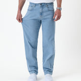 The Jeans Relaxed Straight Fit in light blue — stretching the denim fabric to show flexibility