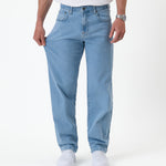 The Jeans Relaxed Straight Fit in light blue — hand pulling the fabric to show stretch