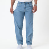 The Jeans Relaxed Straight Fit in light blue — hand pulling the fabric to show stretch