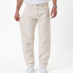 The Jeans Relaxed Straight Fit in ecru — pulling the fabric to demonstrate stretch