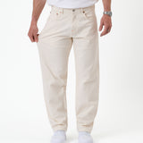 The Jeans Relaxed Straight Fit in ecru — pulling the fabric to demonstrate stretch