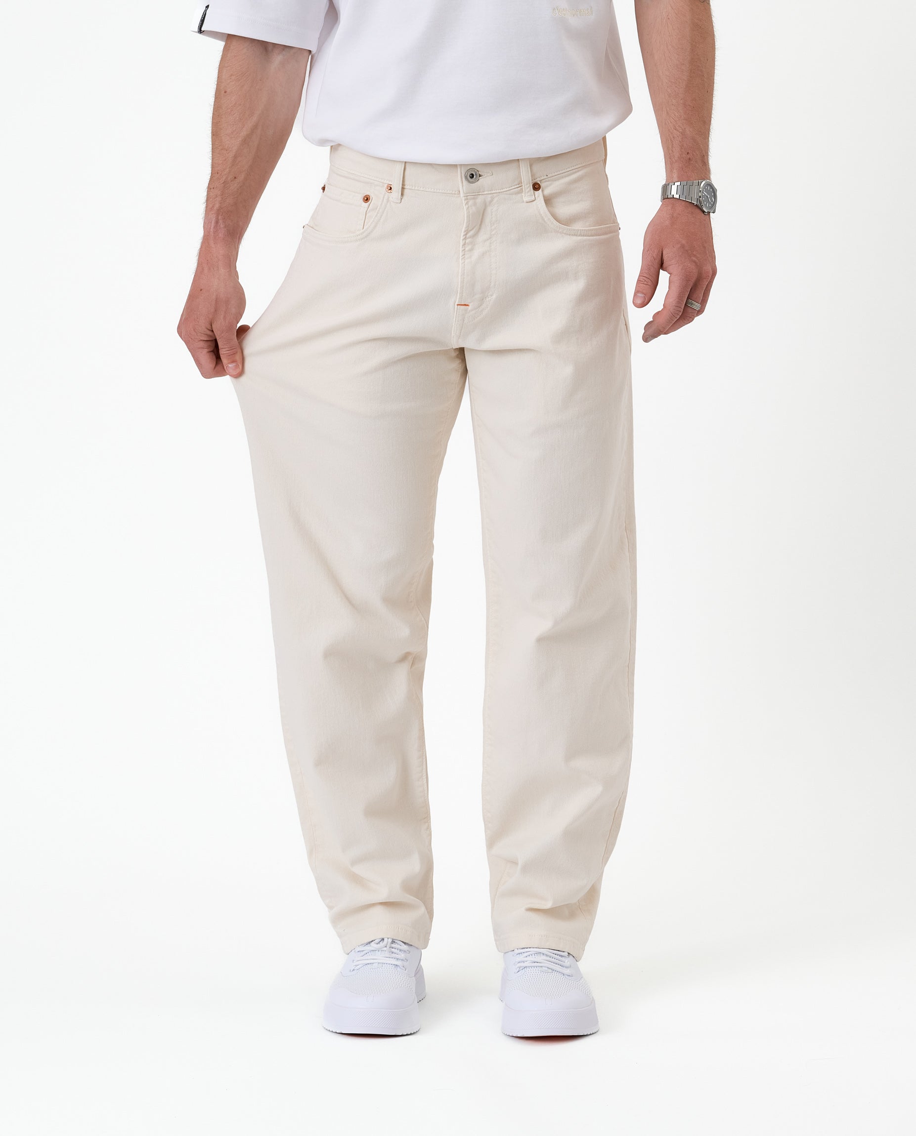 The Jeans Relaxed Straight Fit in ecru — pulling the fabric to demonstrate stretch