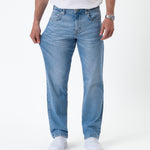 The Jeans Classic Straight Fit in light mid blue — pulling the fabric on the thigh