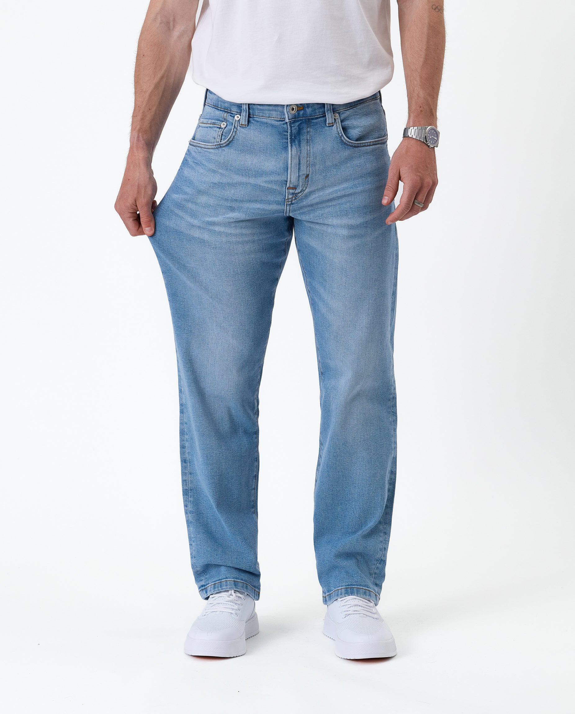 The Jeans Classic Straight Fit in light mid blue — pulling the fabric on the thigh
