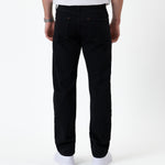 The Jeans Classic Straight Fit in Jet Black — back view worn with white sneakers