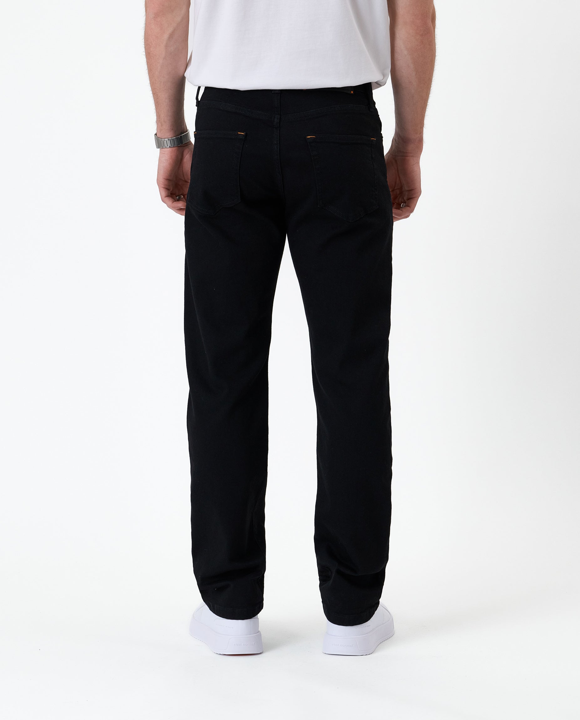 The Jeans Classic Straight Fit in Jet Black — back view worn with white sneakers