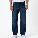 The Jeans Classic Straight Fit in Mid Wash Blue — front view on a model with white sneakers