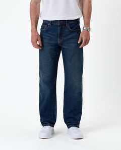 The Jeans Classic Straight Fit in Mid Wash Blue — front view on a model with white sneakers