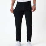 The Jeans Slim Fit in jet black — pulling the fabric to demonstrate the Motion Fabric stretch