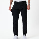 The Jeans Slim Fit in jet black — pulling the fabric to demonstrate the Motion Fabric stretch