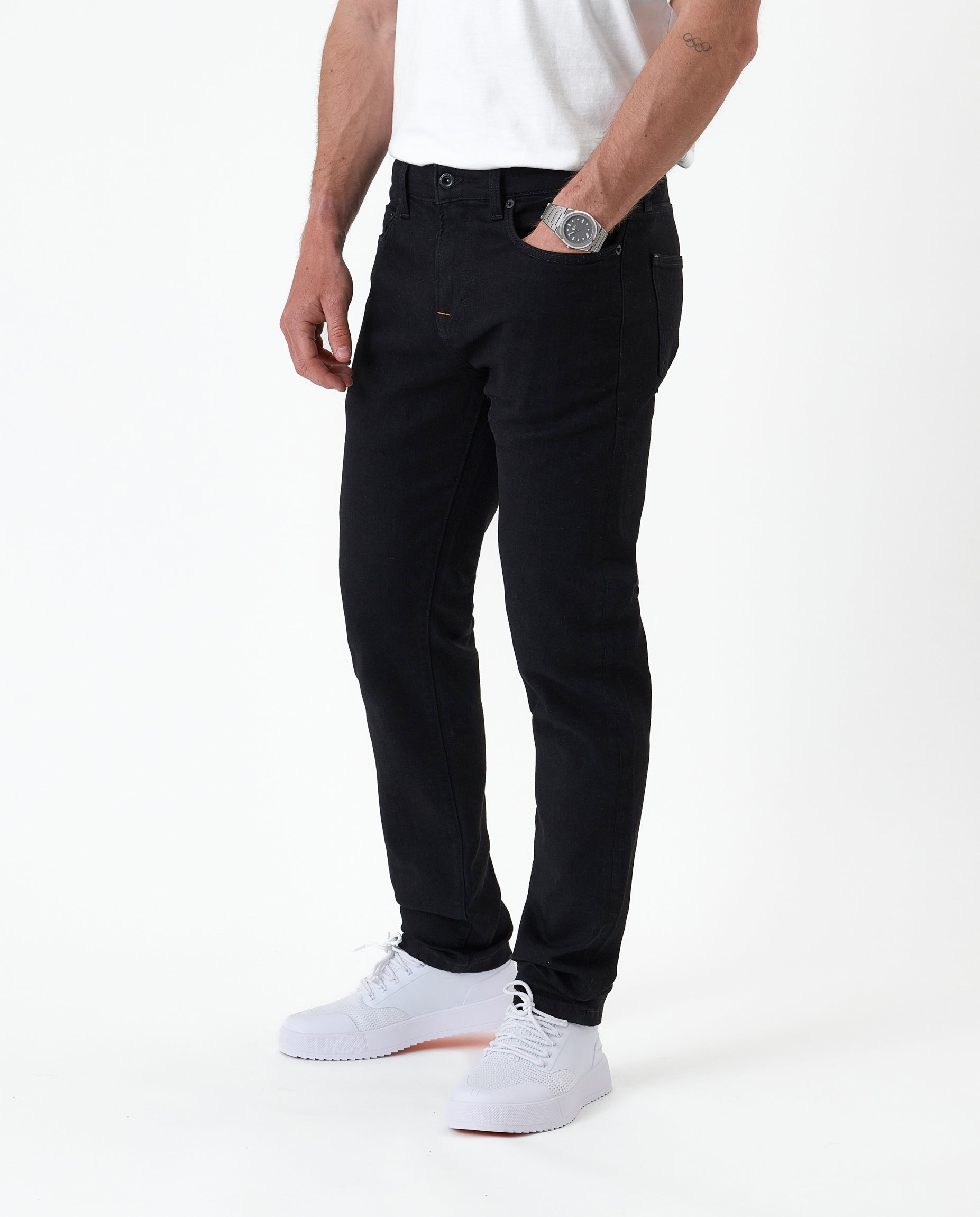 The Jeans Slim Fit in Jet Black — front view worn with white sneakers
