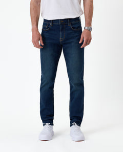 The Jeans Slim Fit in dark blue — front view worn with white sneakers