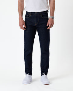 The Jeans Slim Fit in rinse wash — front view with white sneakers