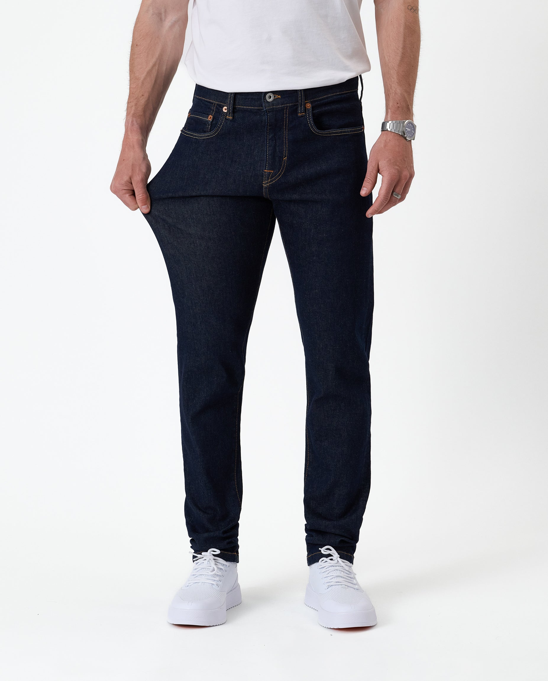 The Jeans Slim Fit in Rinse Wash — demonstrating the stretch of the Motion Fabric
