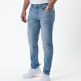 The Jeans Slim Fit in light midwash — worn with white sneakers