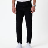 The Jeans Skinny Fit in jet black — front view worn with white sneakers