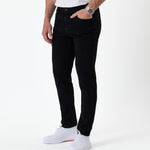The Jeans Skinny Fit in Jet Black — worn with white sneakers