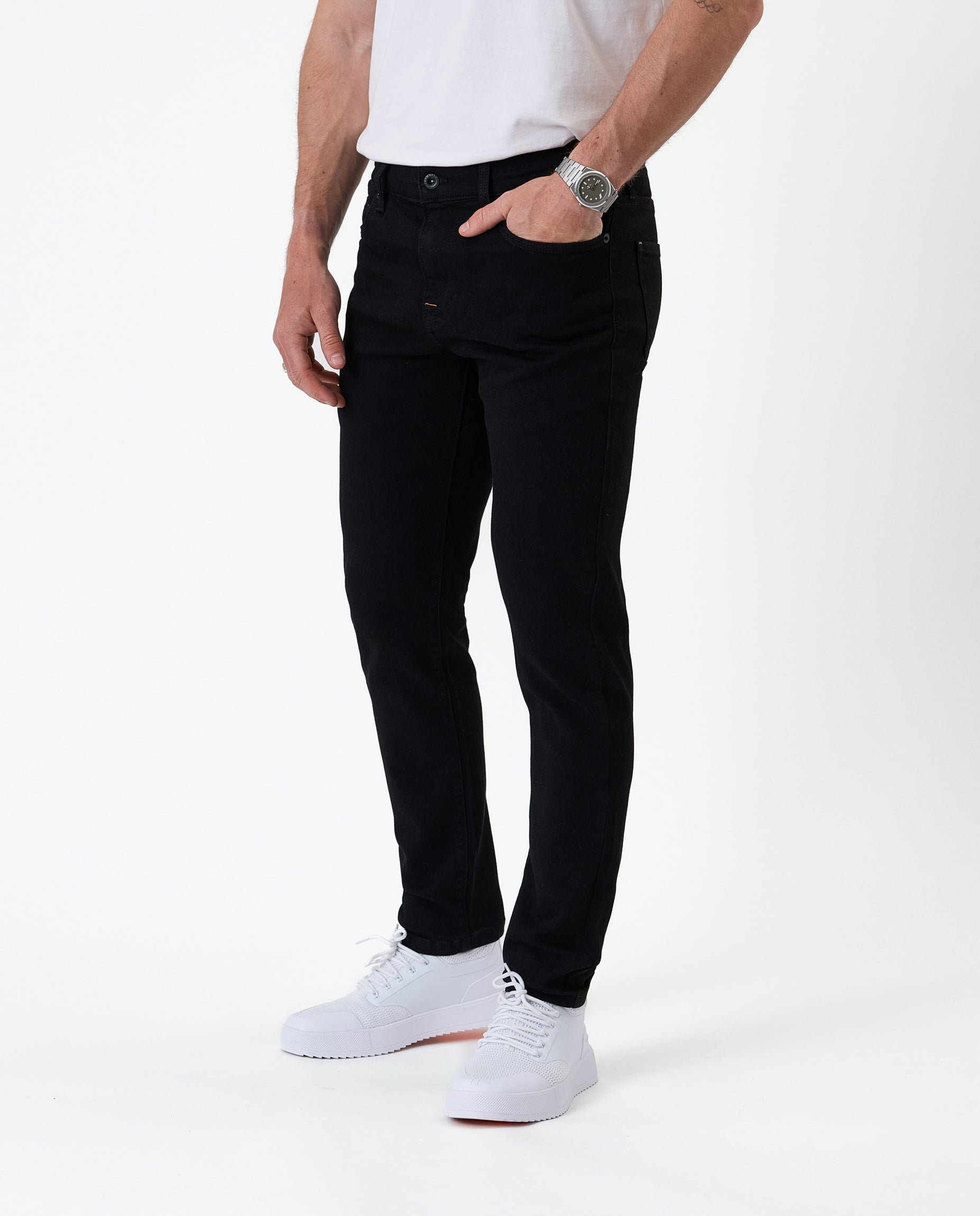 The Jeans Skinny Fit in Jet Black — worn with white sneakers