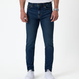The Jeans Skinny Fit in Midwash — front view worn with white sneakers