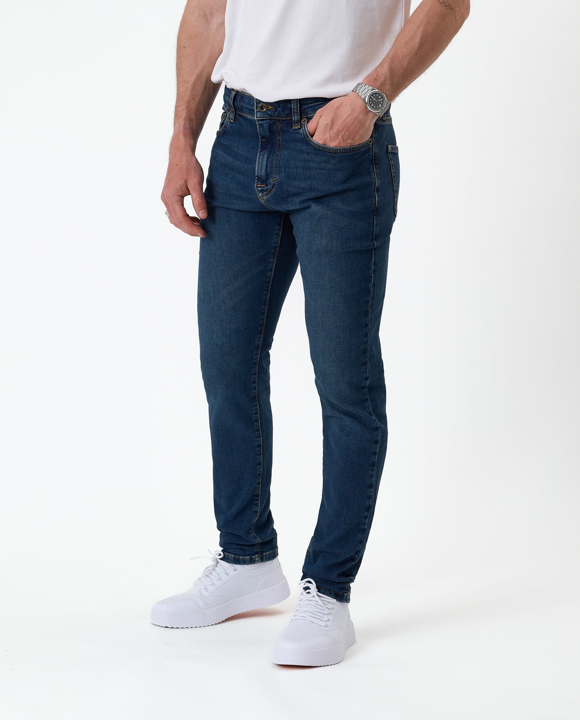 The Jeans Skinny Fit in midwash — worn with white sneakers
